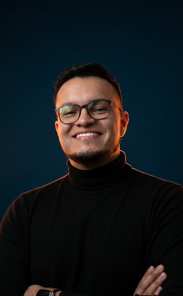 Lucas Borges, gestor de tráfego, sorrindo de braços cruzados
